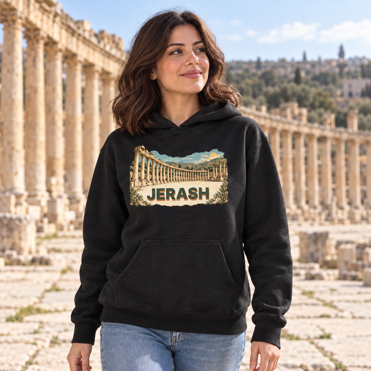 Black hoodie curving limestone colonnade and olive hills with dark olive JERASH lettering and a sandy solid shadow on pale stone foreground