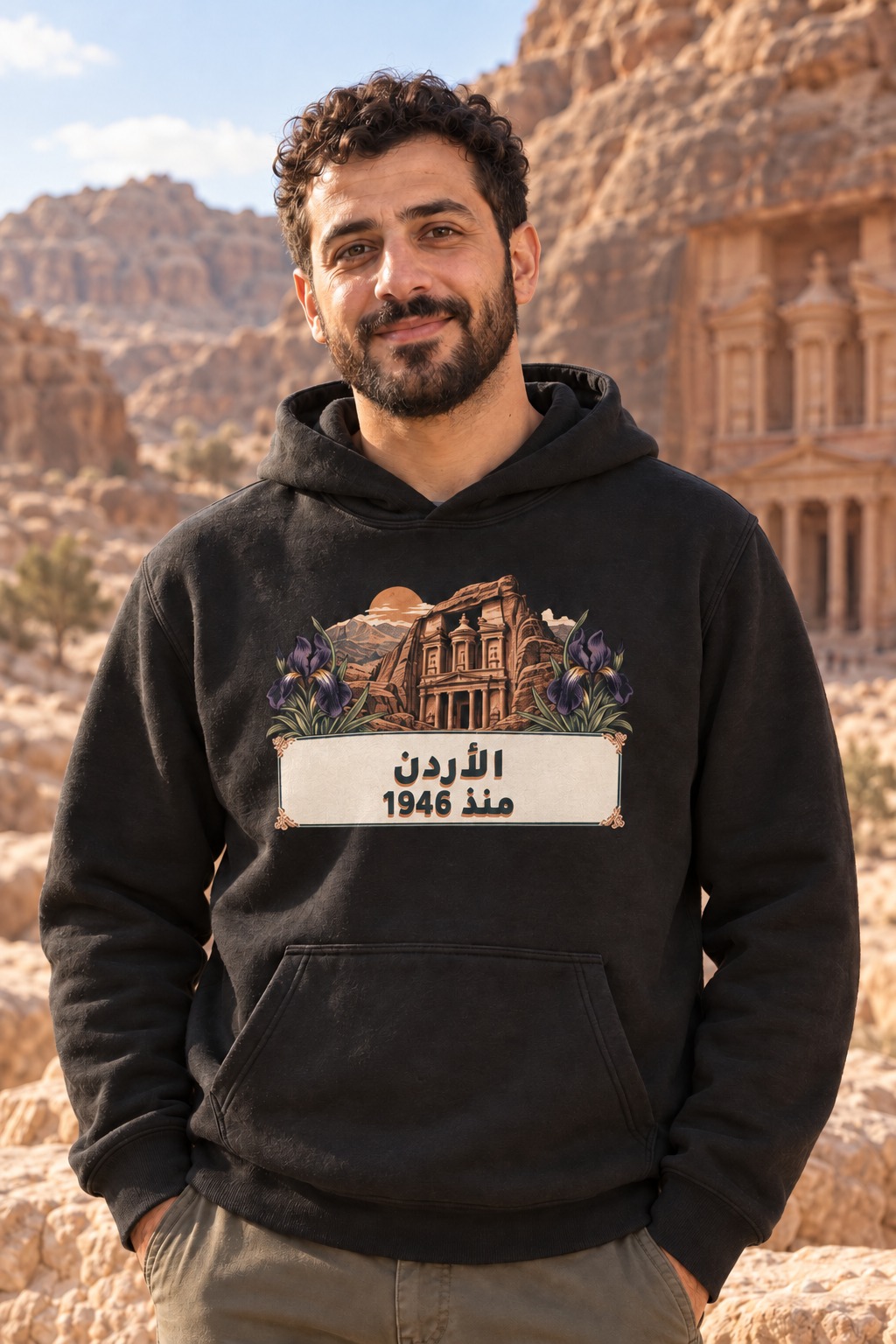 هودي أسود واجهة صخرية مستوحاة من البتراء وسوسن داكن وشمس نحاسية، فوق مساحة عاجية تحمل الأردن منذ 1946 بخط بترولي وظل دافئ