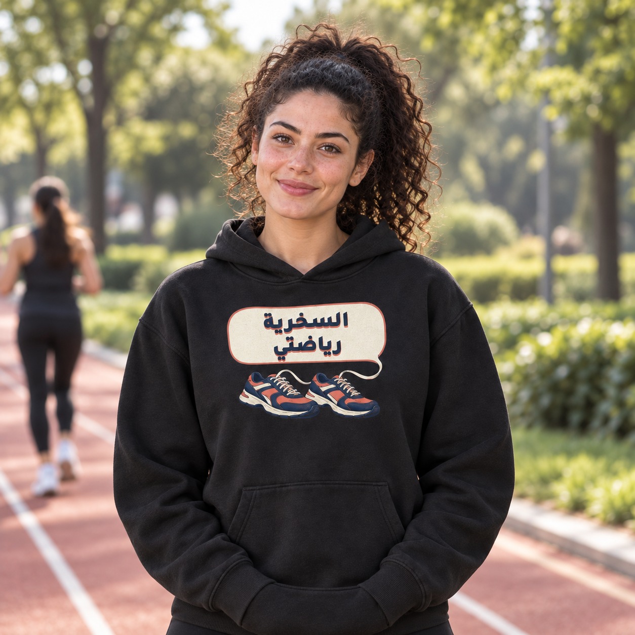 هودي أسود حذاءا جري كلاسيكيان بالكحلي والمرجاني تتحول أربطتهما إلى فقاعة كلام عاجية تحمل السخرية رياضتي بخط كحلي وظل مرجاني